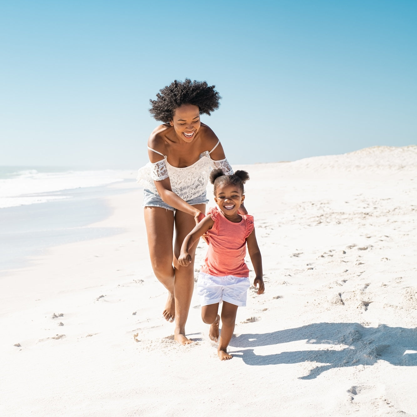 Mother and daughter laughing on the beach